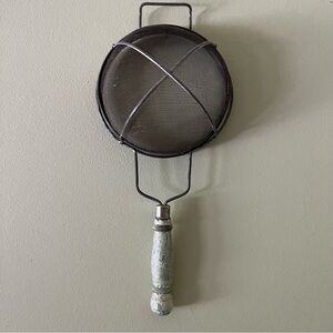 Antique strainer with wooden handle.